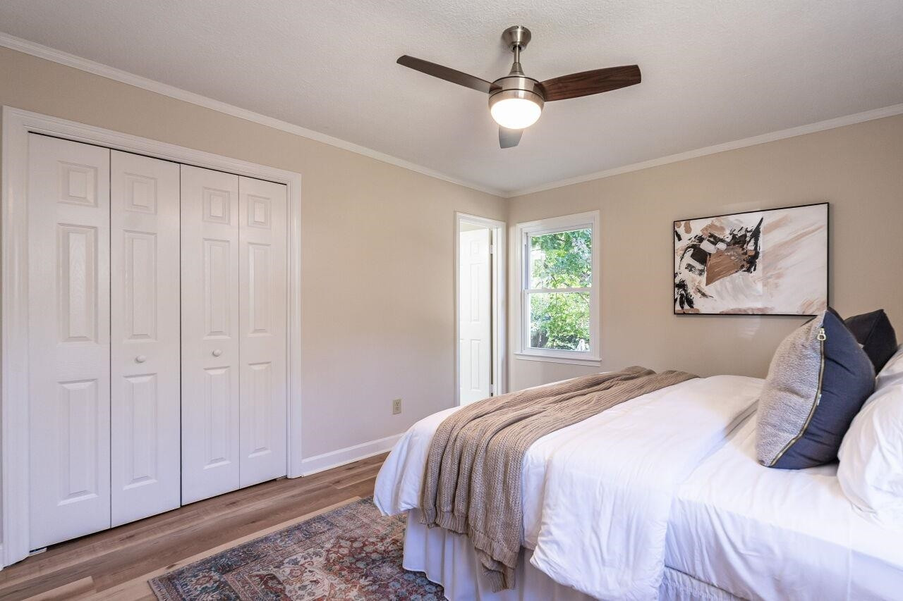 3300 Blue Ridge Road Raleigh, NC 27612 - Photo 17 of 25 a bedroom with a large bed and a chandelier