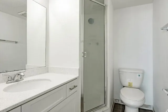 a bathroom with a toilet sink vanity and mirror