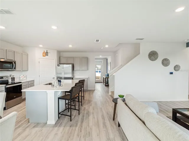 a kitchen with a sink a counter top space stainless steel appliances and cabinets