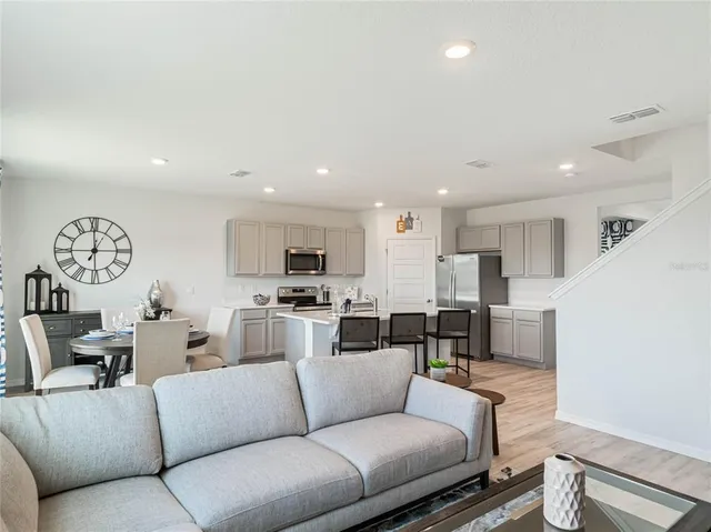 a living room with furniture and a view of kitchen