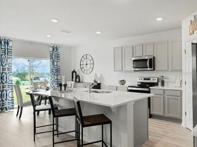 a kitchen with a dining table chairs and sink