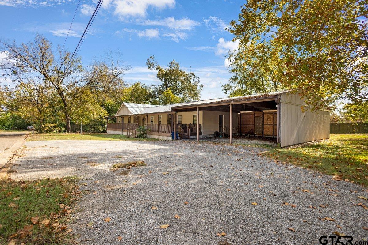 a front view of house with yard and trees in the background