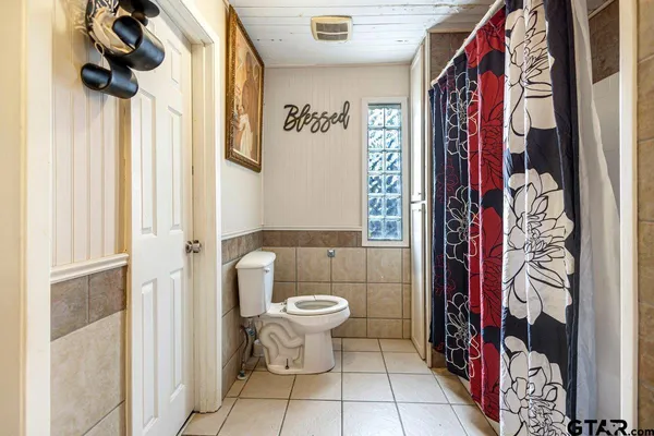 a bathroom with a toilet and a shower curtain