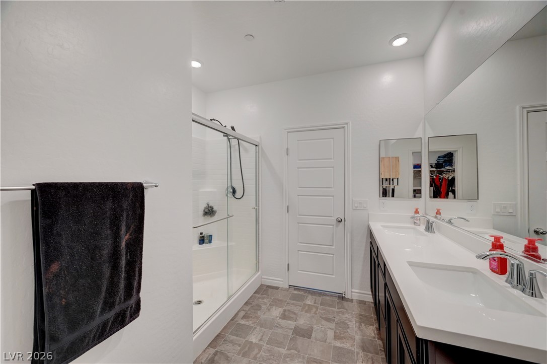 7204 North Decatur Boulevard, Unit 3 North Las Vegas, NV 89084 - Photo 22 of 48 A pristine primary bathroom features a spacious shower and a wide vanity with dual sinks.