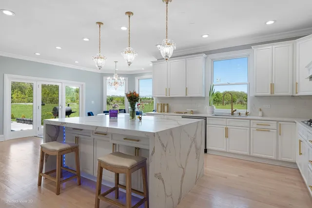 a kitchen with kitchen island granite countertop a sink a center island and cabinets