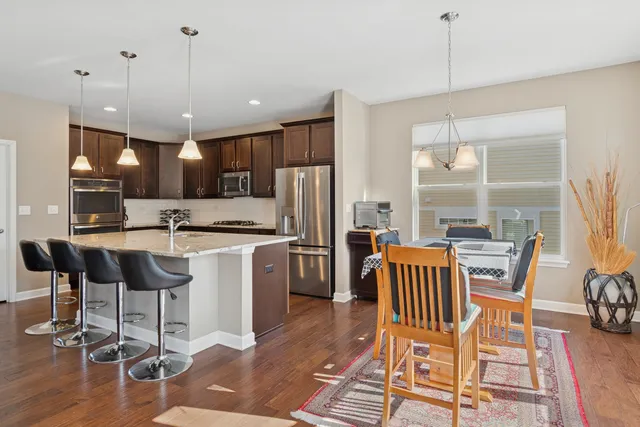a kitchen with a dining table chairs and refrigerator