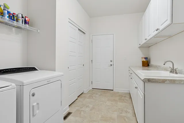 a utility room with sink dryer and washer