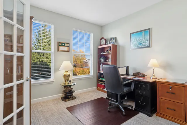 a view of a workspace with furniture and a window