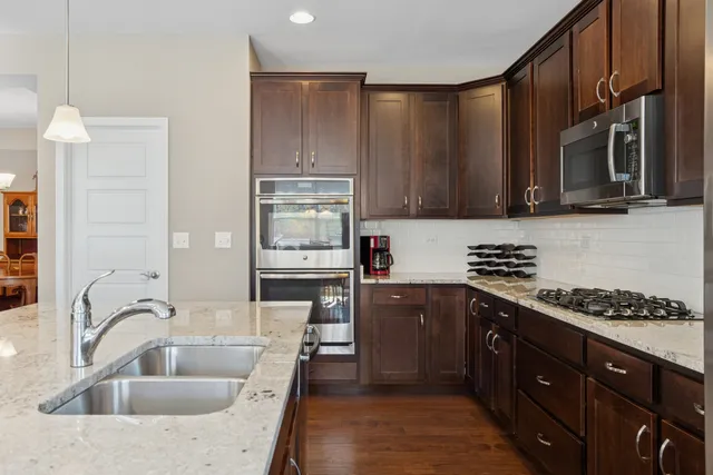 a kitchen with stainless steel appliances granite countertop a sink stove and refrigerator