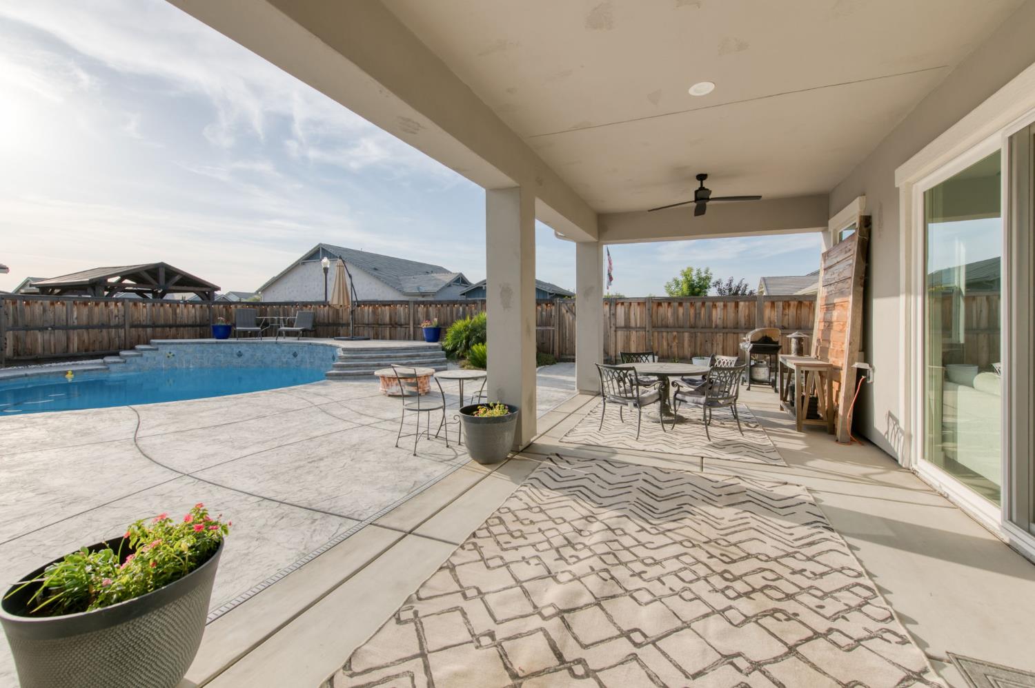 1736 North Renn Avenue Clovis, CA 93619 - Photo 36 of 66 a view of a patio with dining table and chairs with a barbeque grill and couches
