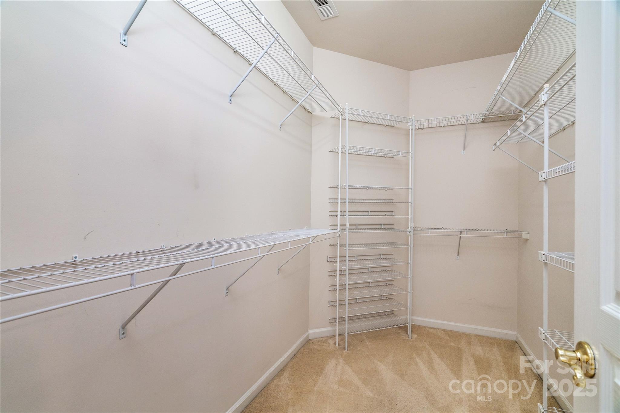 9514 Kestral Ridge Drive Charlotte, NC 28269 - Photo 23 of 32 a view of walk in closet with empty racks