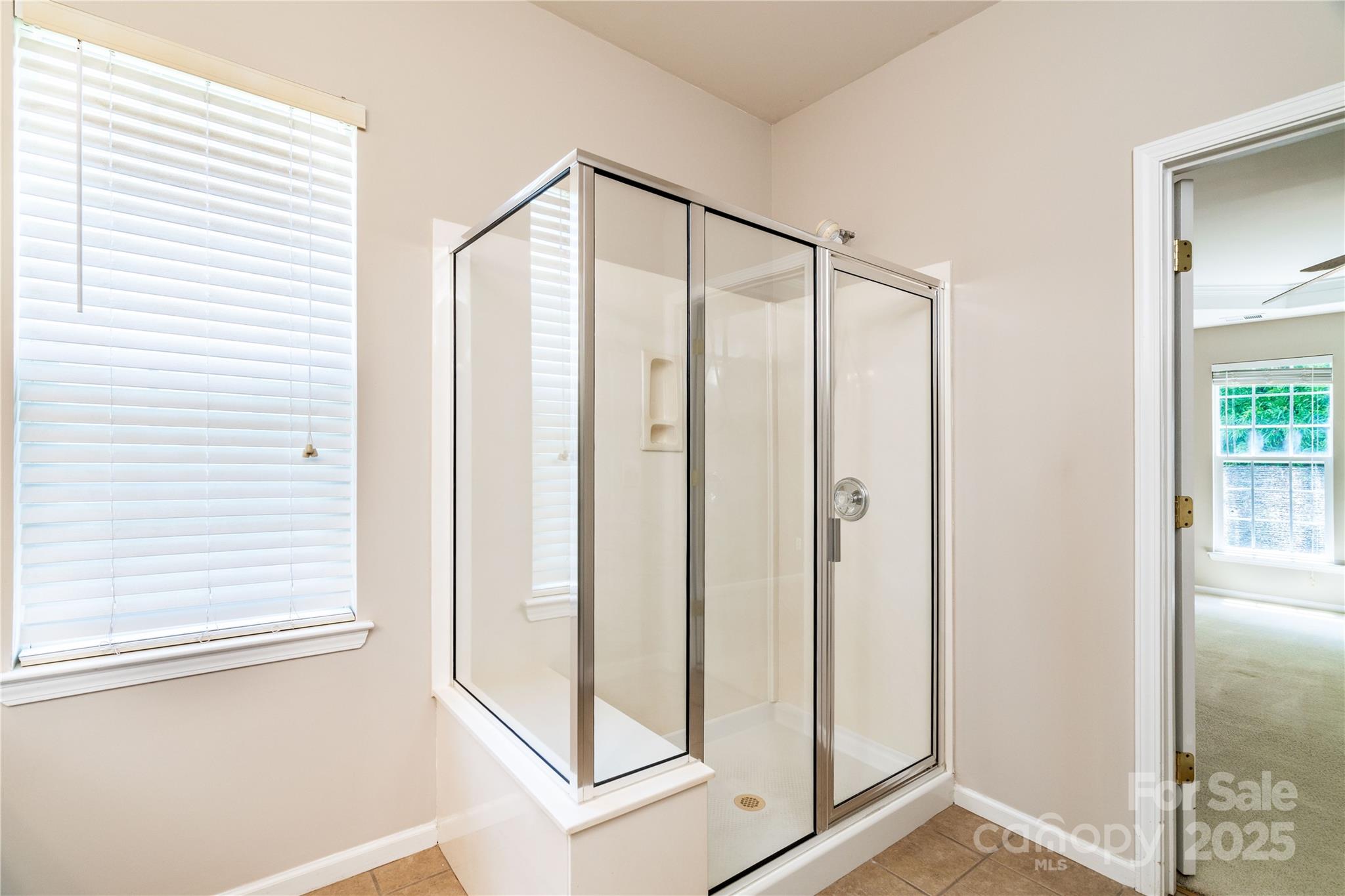 9514 Kestral Ridge Drive Charlotte, NC 28269 - Photo 24 of 32 a bathroom with a glass shower door