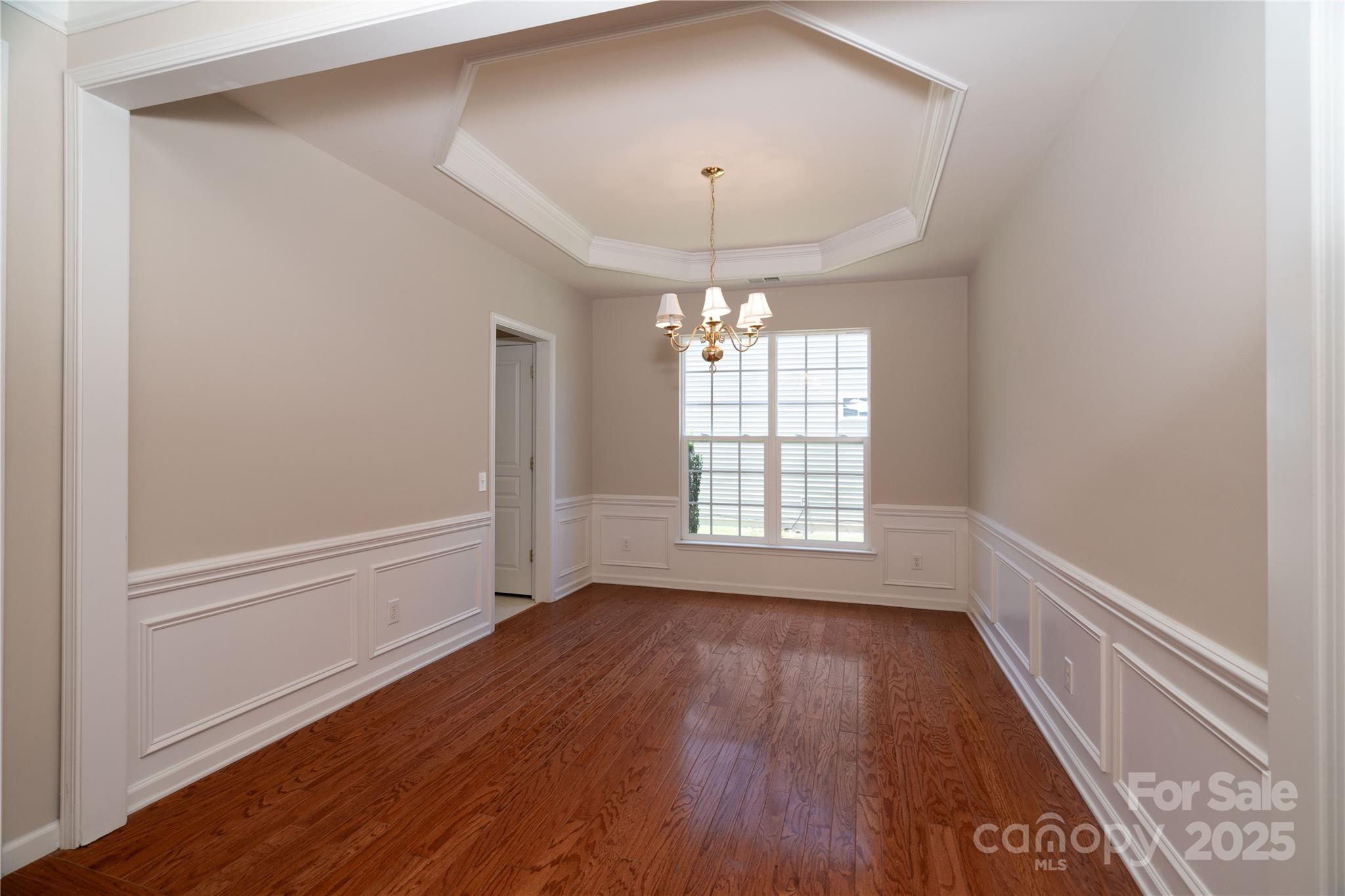 9514 Kestral Ridge Drive Charlotte, NC 28269 - Photo 6 of 32 a view of an empty room with wooden floor and a window