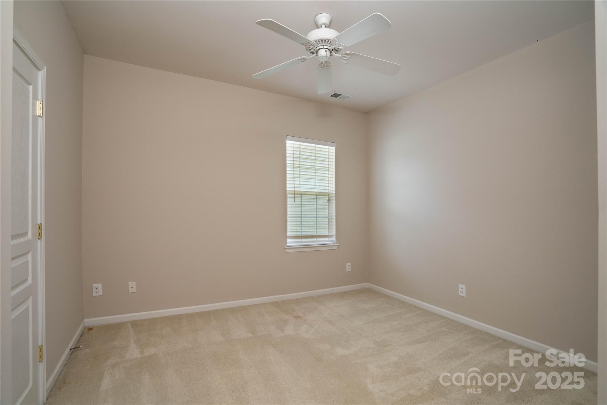 9514 Kestral Ridge Drive Charlotte, NC 28269 - Photo 9 of 32 an empty room with a window and a fan