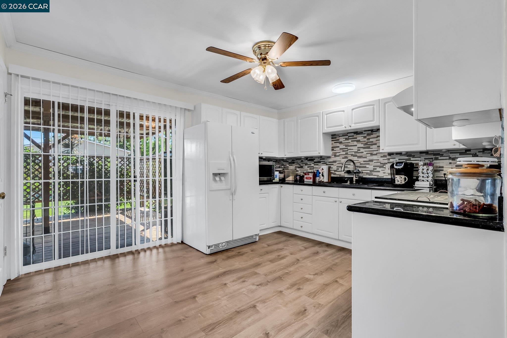 183 West Leland Road Pittsburg, CA 94565 - Photo 5 of 21 a kitchen with wooden floor and a window