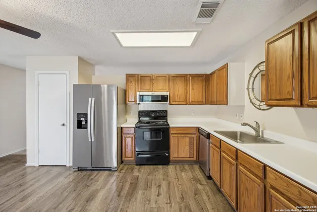 a kitchen with a sink appliances and cabinets