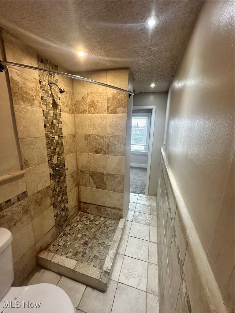 4658 Rockwood Road Cleveland, OH 44125 - Photo 10 of 18 Full bathroom with toilet, a stall shower, tile patterned floors, and a textured ceiling
