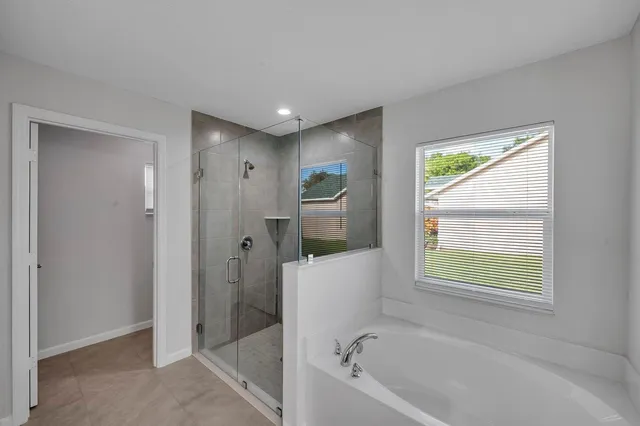 a bathroom with a bathtub shower and window