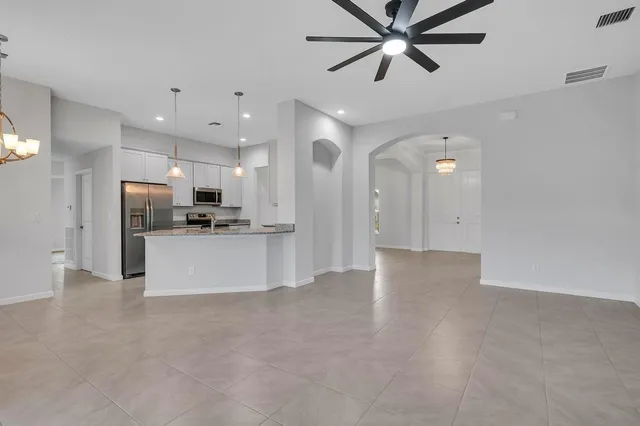 a view of a kitchen with refrigerator and a ceiling fan