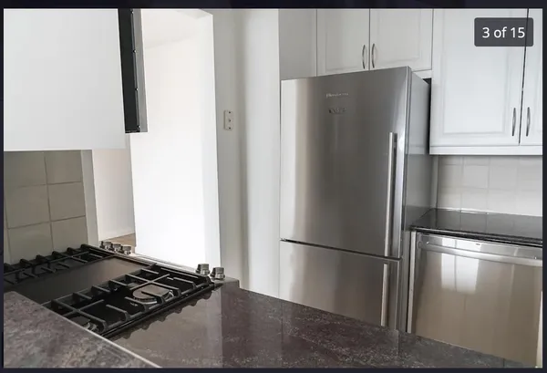 a metallic refrigerator freezer sitting in a kitchen