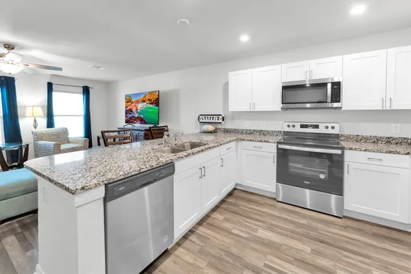 a kitchen with kitchen island a sink stove and refrigerator