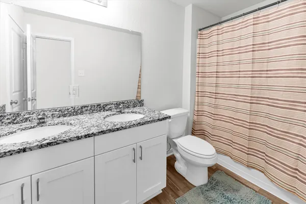 a bathroom with a granite countertop sink toilet and shower