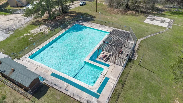 an aerial view of a residential houses with outdoor space and lake view