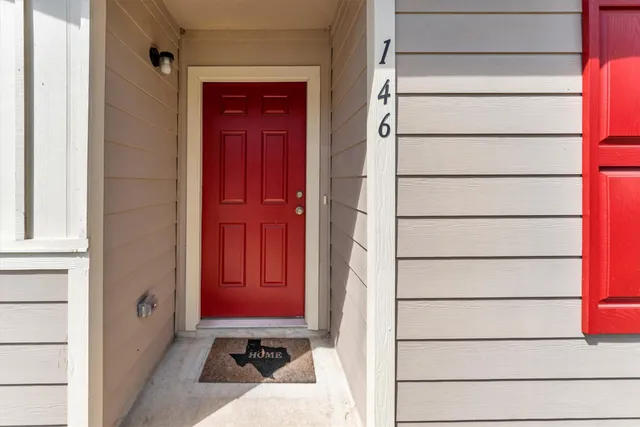 a living room with furniture and three large window