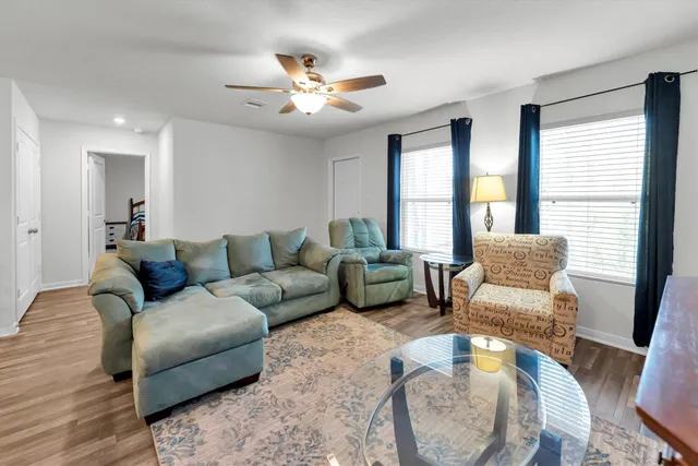 a kitchen with stainless steel appliances granite countertop a sink dishwasher stove and white cabinets with wooden floor