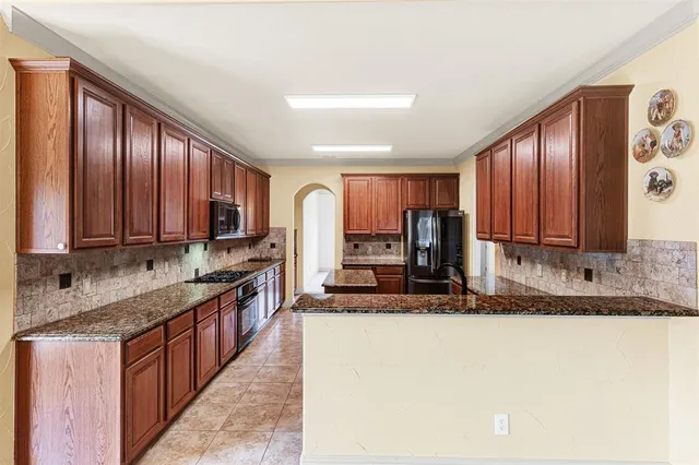 a kitchen with stainless steel appliances granite countertop a sink stove and cabinets