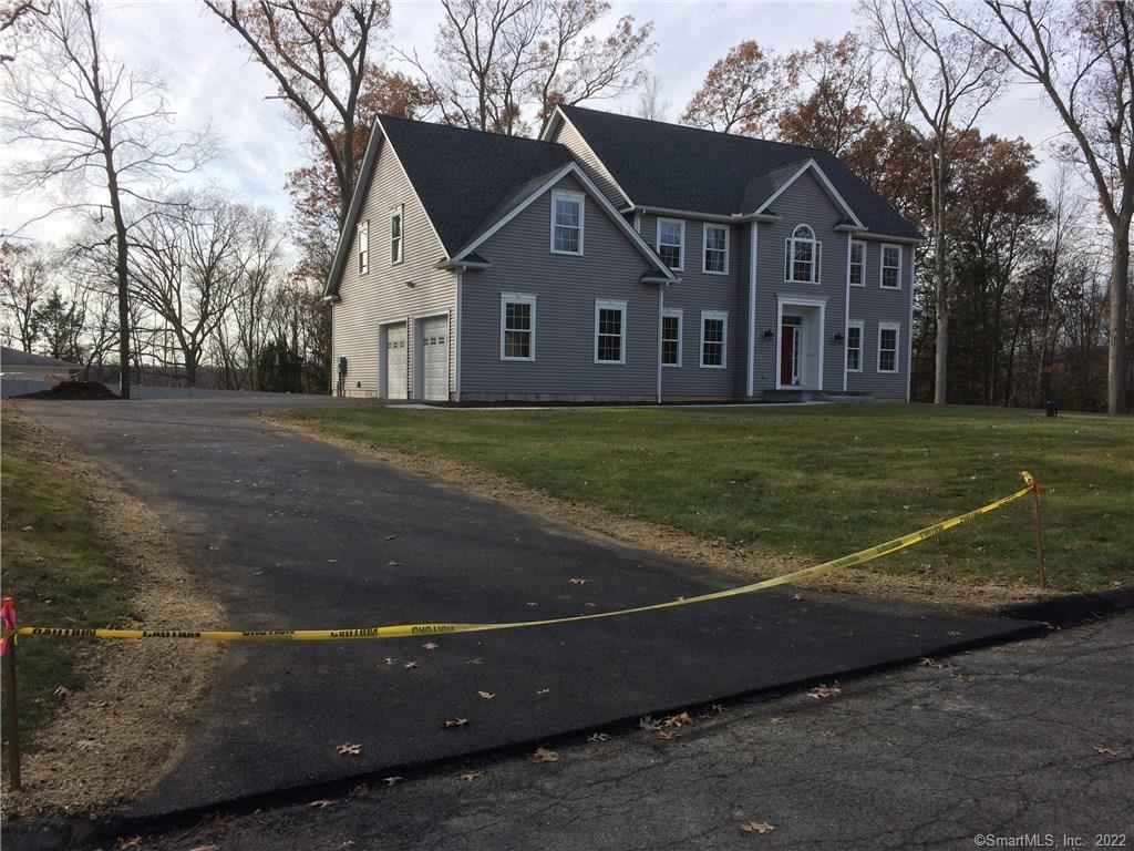 a view of big house with a big yard and large trees