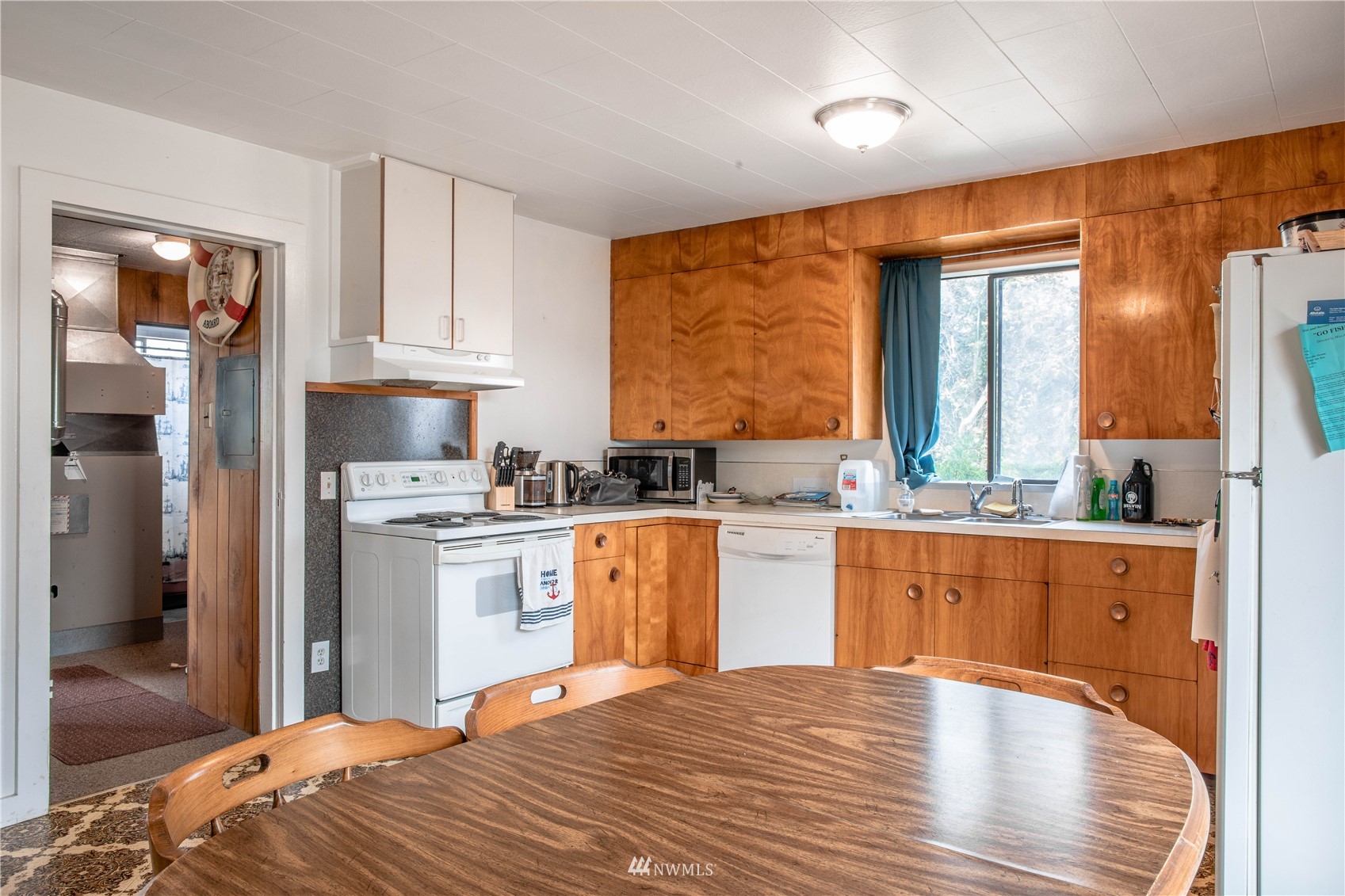 6783 Kickerville Road Ferndale, WA 98248 - Photo 6 of 22 a kitchen with stainless steel appliances granite countertop a refrigerator a sink dishwasher and wooden cabinets with wooden floor