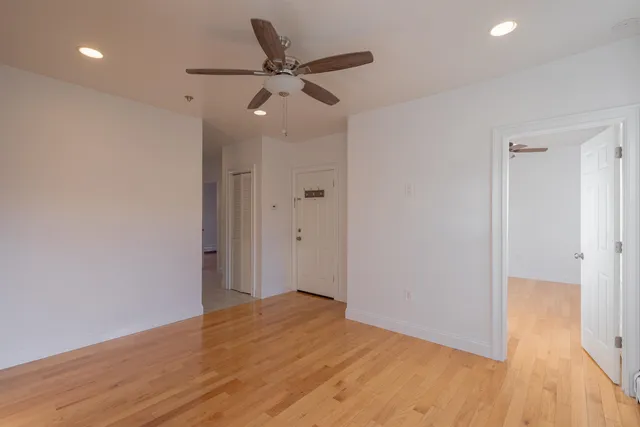 a view of a big room with wooden floor and windows
