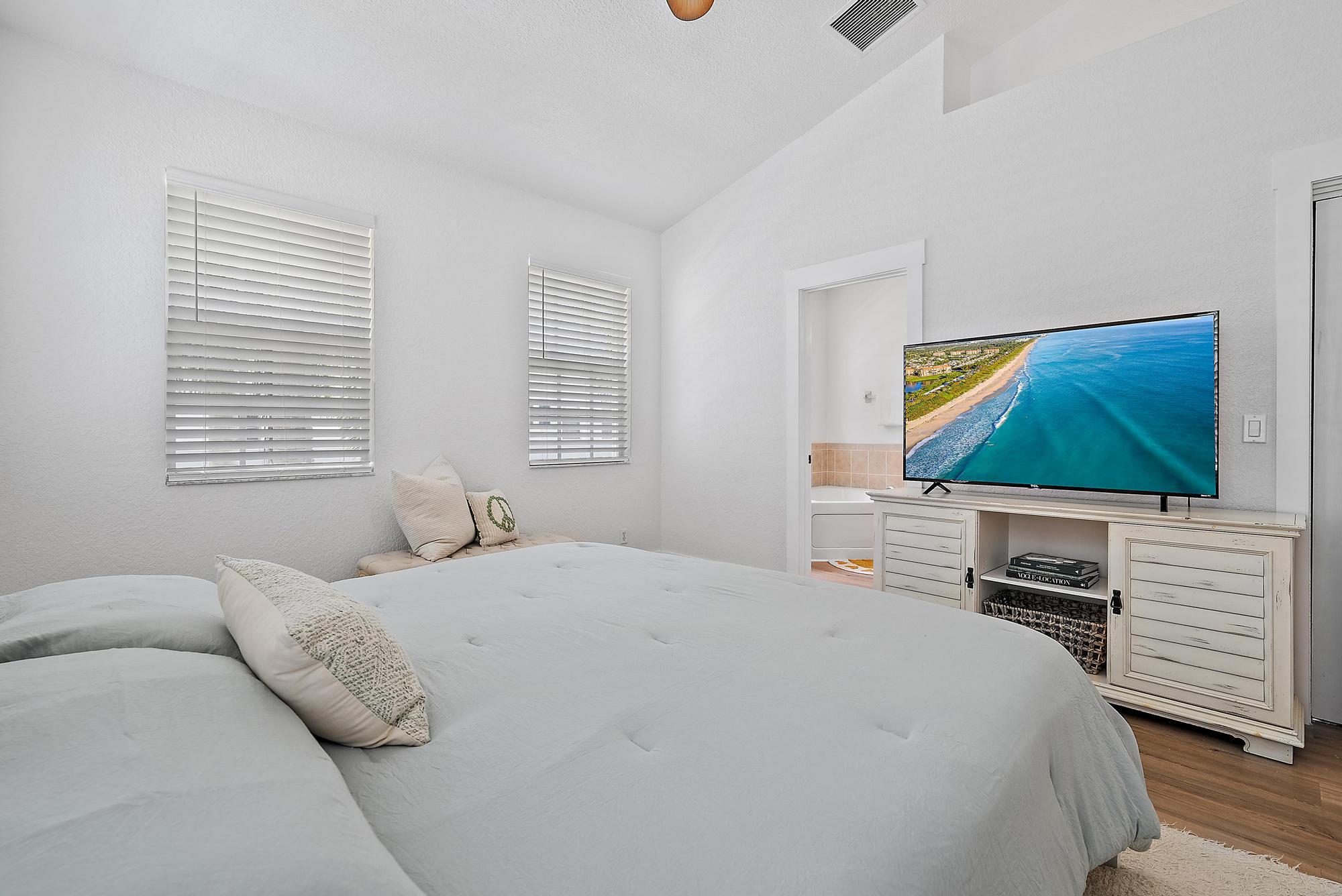 107 Pond Apple Lane, Unit 105 Jupiter, FL 33458 - Photo 17 of 37 a bedroom with a bed and a flat screen tv