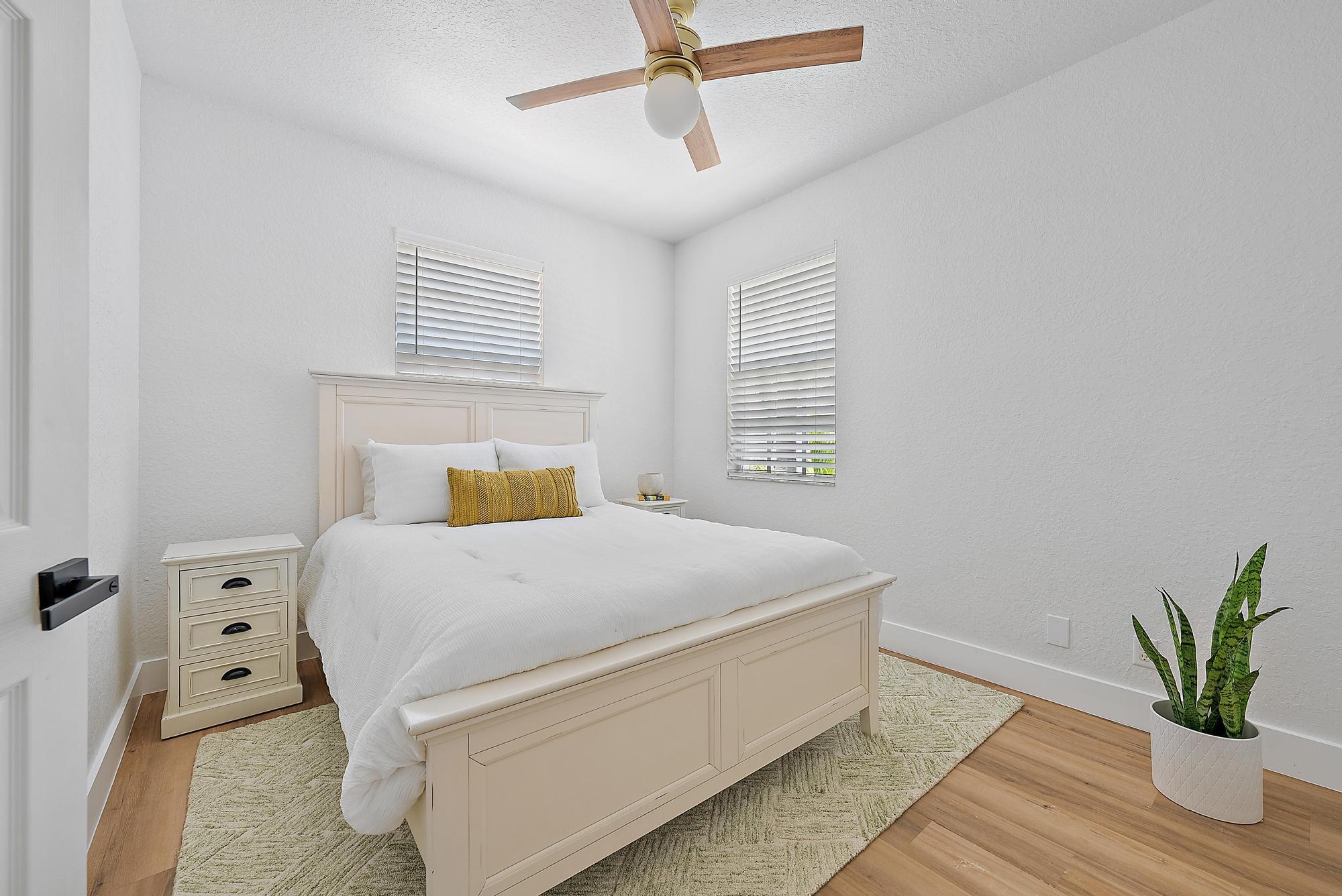 107 Pond Apple Lane, Unit 105 Jupiter, FL 33458 - Photo 20 of 37 a bedroom with a bed and a potted plant