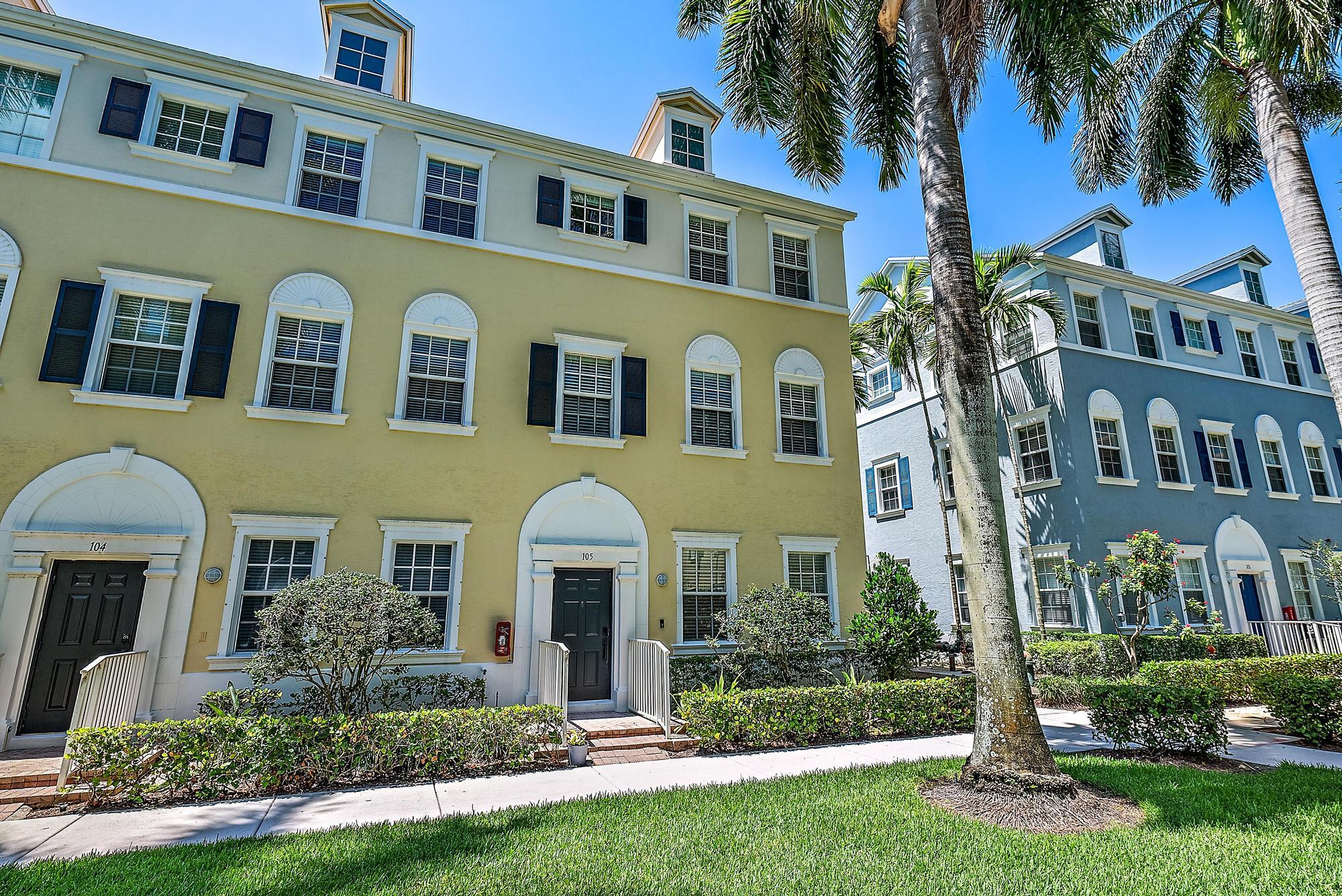 107 Pond Apple Lane, Unit 105 Jupiter, FL 33458 - Photo 2 of 37 a front view of a house with a yard and potted plants