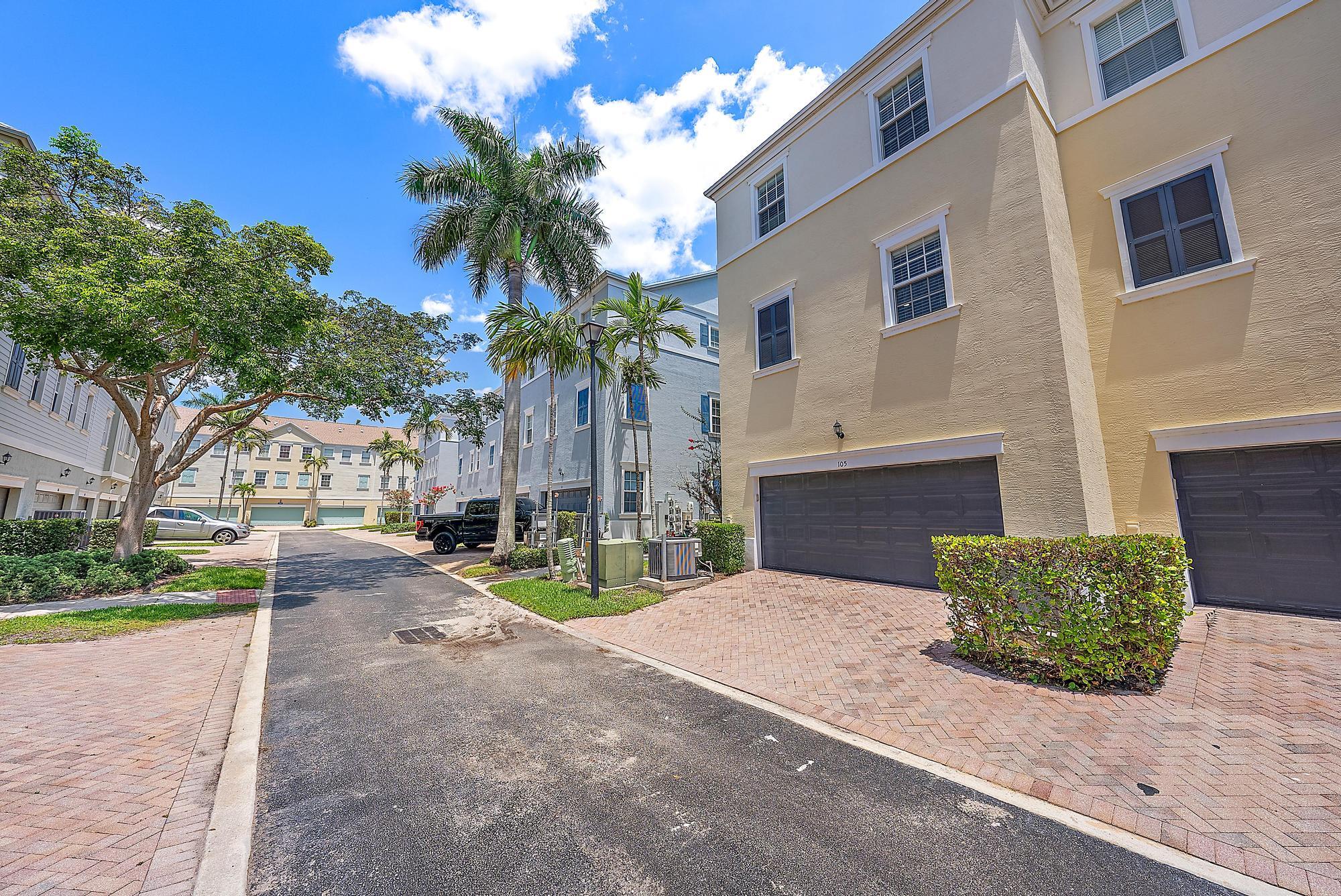 107 Pond Apple Lane, Unit 105 Jupiter, FL 33458 - Photo 26 of 37 a view of a house with a yard and potted plants