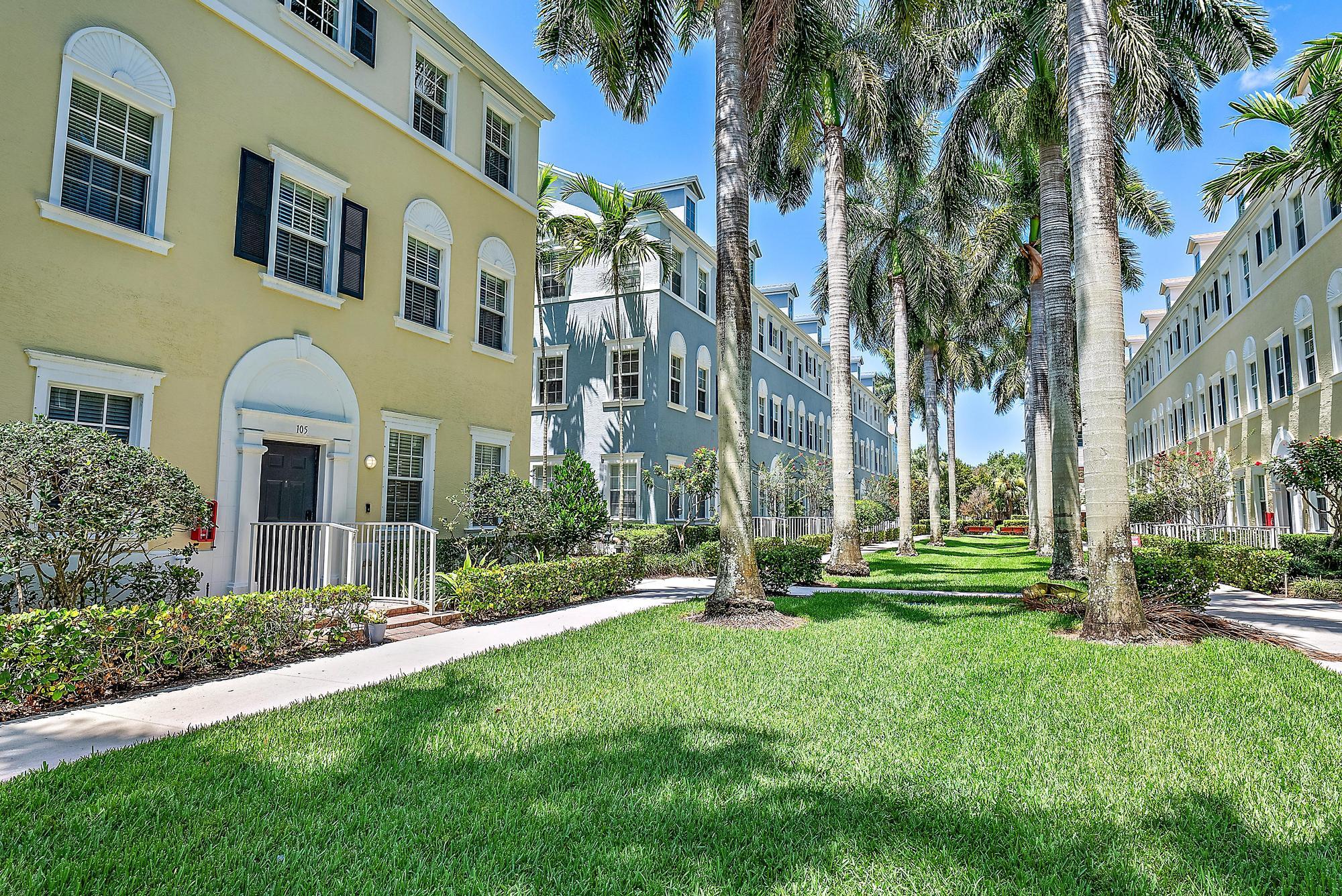107 Pond Apple Lane, Unit 105 Jupiter, FL 33458 - Photo 3 of 37 a front view of a multi story residential apartment building with yard and green space