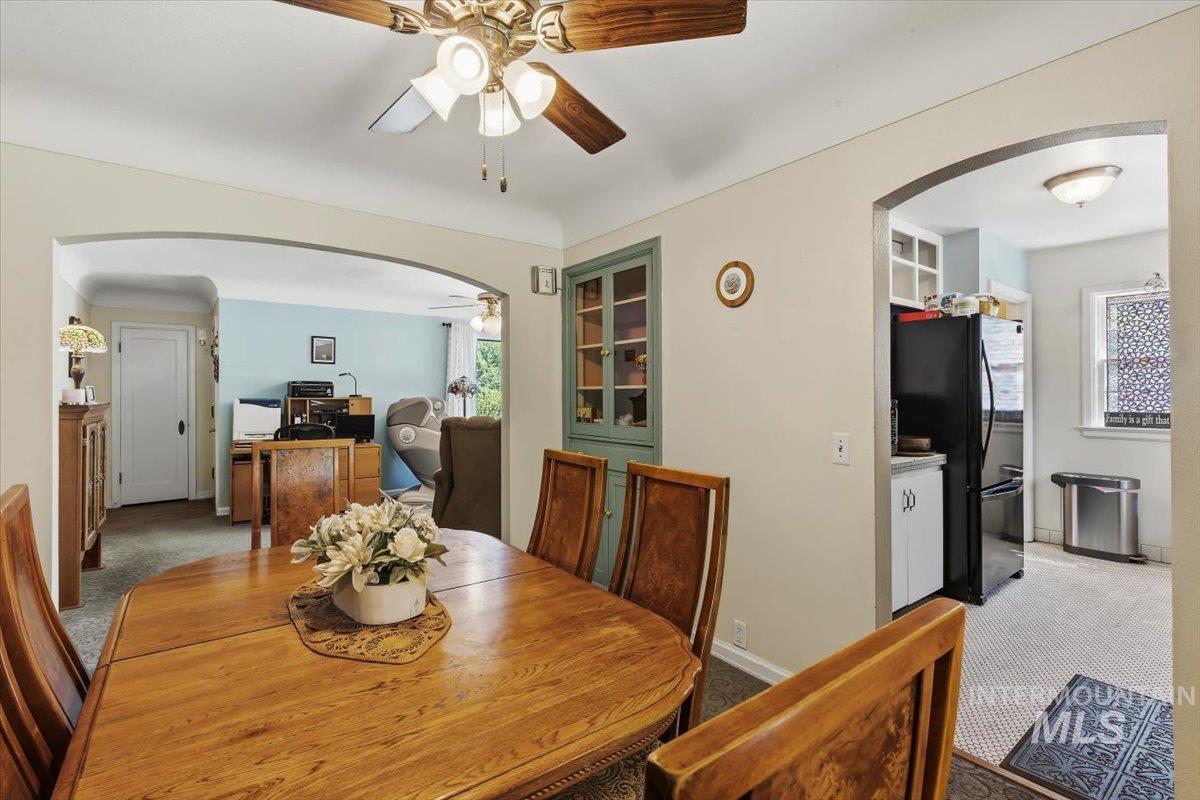 4619 Freemont Street Boise, ID 83706 - Photo 6 of 27 Dining area featuring a wood-finish table, a ceiling fan with integrated lighting, and an arched doorway opening to an additional room