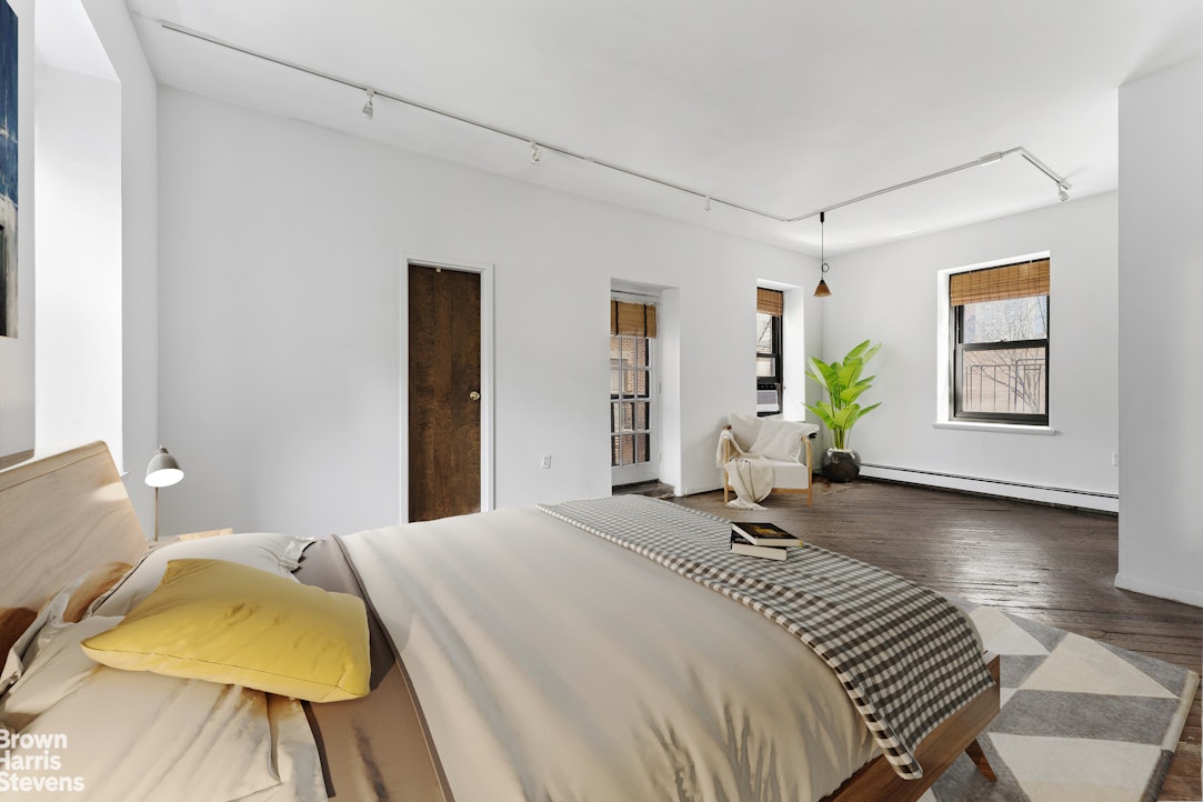 454 West 46th Street, Unit 4CS Manhattan, NY 10036 - Photo 11 of 18 a bedroom with a bed and wooden floor