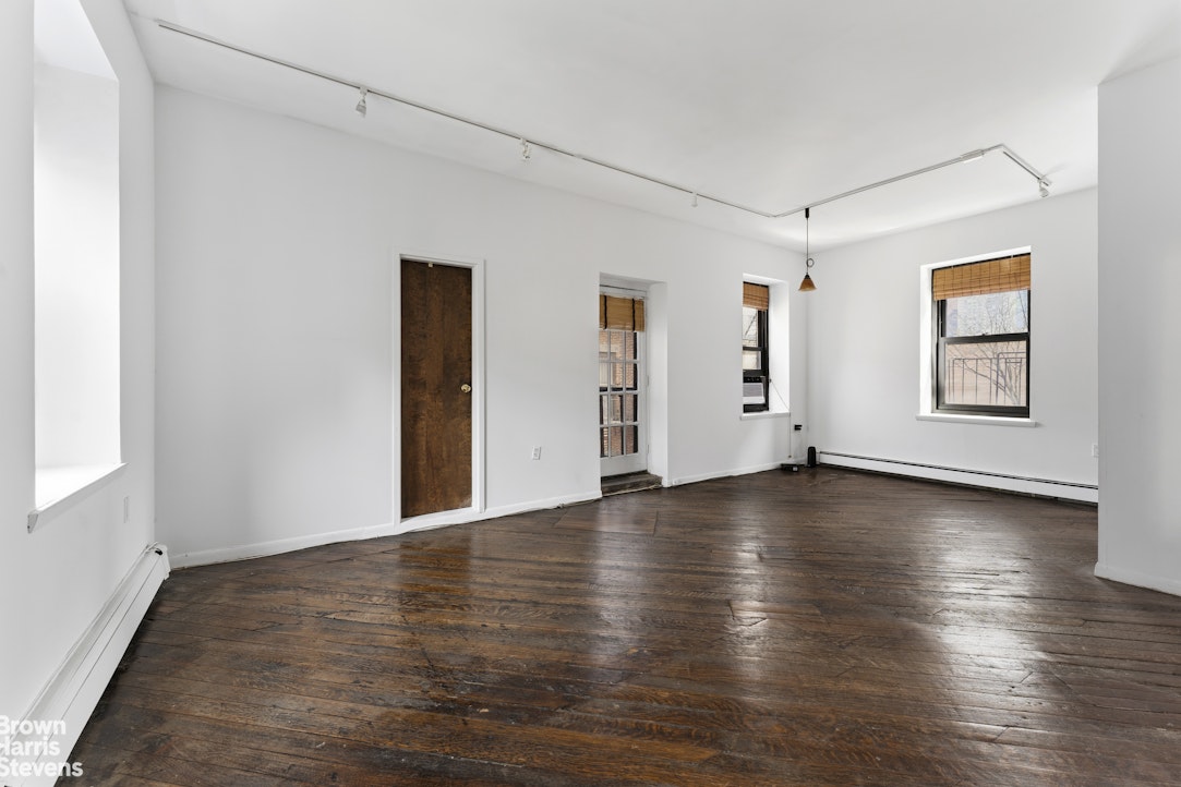 454 West 46th Street, Unit 4CS Manhattan, NY 10036 - Photo 12 of 18 an empty room with wooden floor and windows