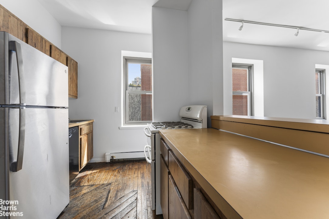 454 West 46th Street, Unit 4CS Manhattan, NY 10036 - Photo 13 of 18 a kitchen with a refrigerator a sink and wooden floor