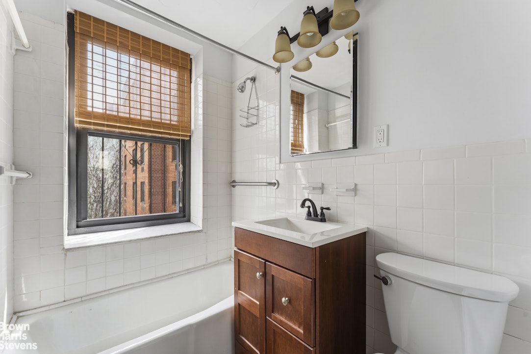 454 West 46th Street, Unit 4CS Manhattan, NY 10036 - Photo 14 of 18 a bathroom with a sink toilet vanity and tub