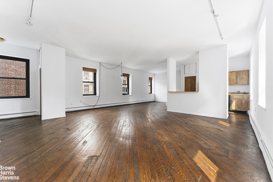 454 West 46th Street, Unit 4CS Manhattan, NY 10036 - Photo 2 of 18 a view of empty room with wooden floor and window