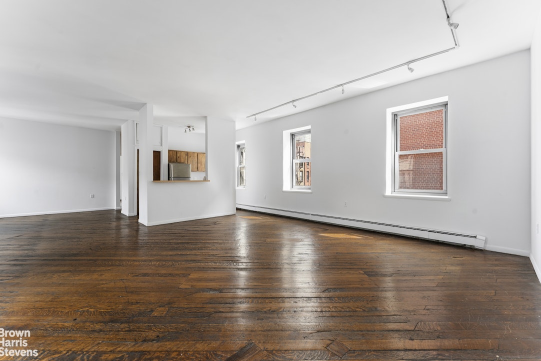 454 West 46th Street, Unit 4CS Manhattan, NY 10036 - Photo 4 of 18 a view of an empty room with window and wooden floor