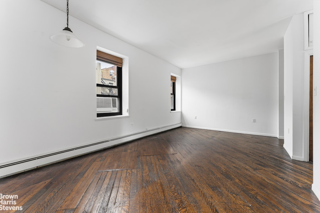 454 West 46th Street, Unit 4CS Manhattan, NY 10036 - Photo 6 of 18 an empty room with wooden floor and windows