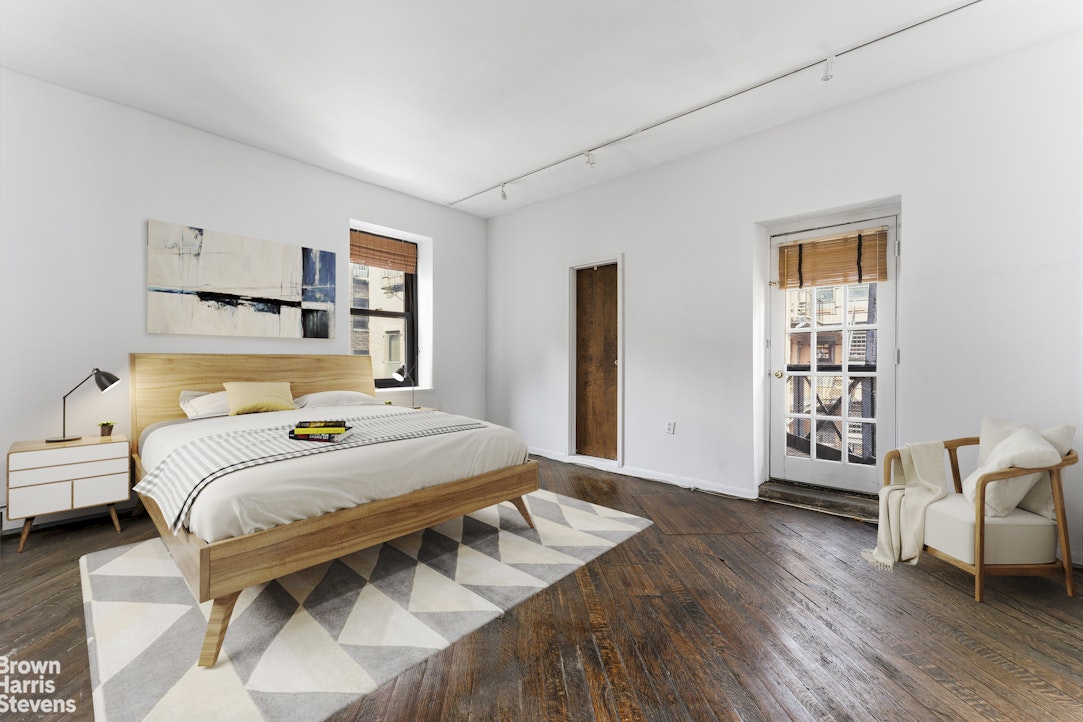 454 West 46th Street, Unit 4CS Manhattan, NY 10036 - Photo 9 of 18 a bedroom with a bed and wooden floor