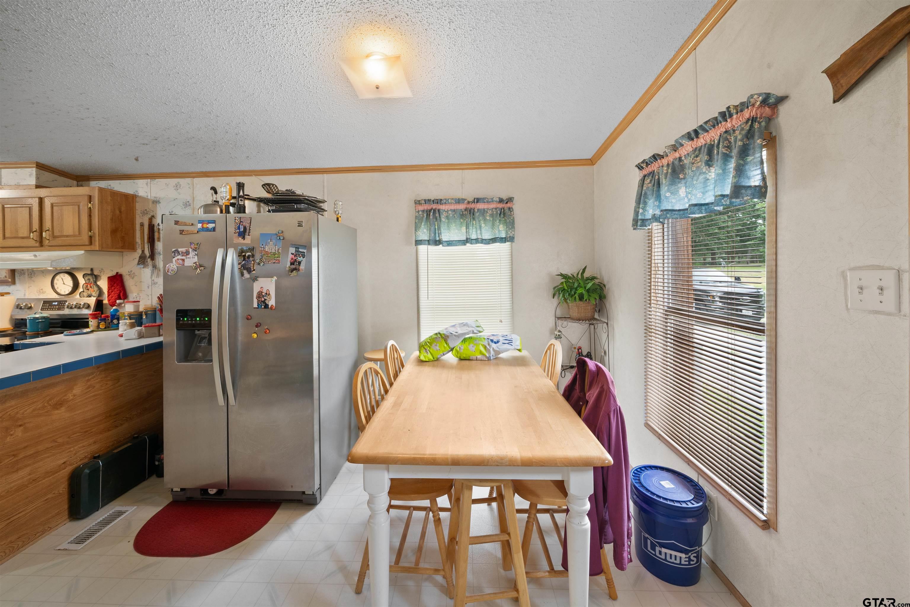 2425 Thompson Lane Tyler, TX 75704 - Photo 15 of 27 a kitchen with stainless steel appliances refrigerator dining table and chairs