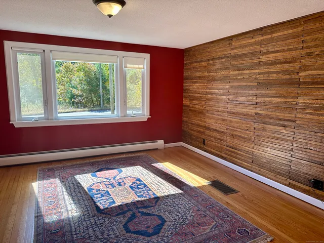 a view of an empty room with furniture and window