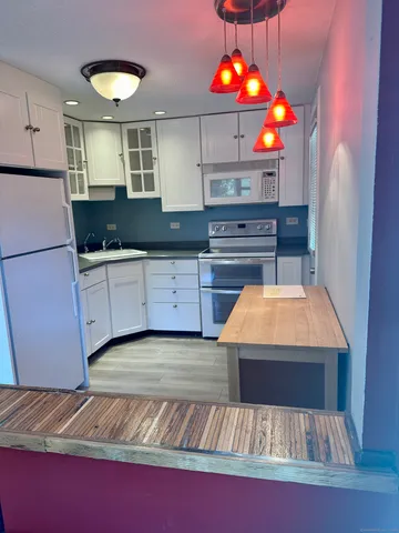 a kitchen with kitchen island granite countertop a sink and a stove